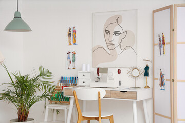 Interior of light atelier with tailor's workplace, painting and sketches