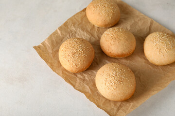 Baking paper of fresh buns with sesame seeds on white background