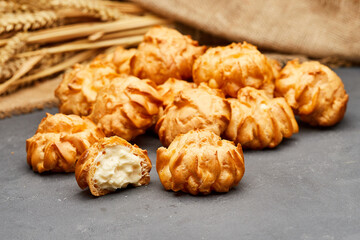 Delicious cream-filled profiteroles arranged on a dark slate surface, perfect for dessert lovers