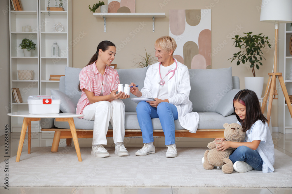 Canvas Prints female pediatrician prescribing pills to mother and little girl at home