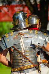 Roman legionaries in metal armour at a historical reenactment party.