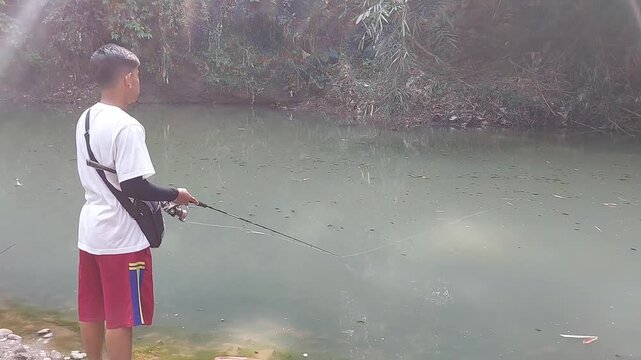 a man who was doing his fishing hobby using casting techniques in a river in the Magelang area, Central Java, Indonesia