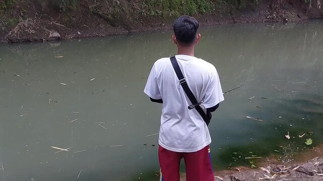 a man who was doing his fishing hobby using casting techniques in a river in the Magelang area, Central Java, Indonesia