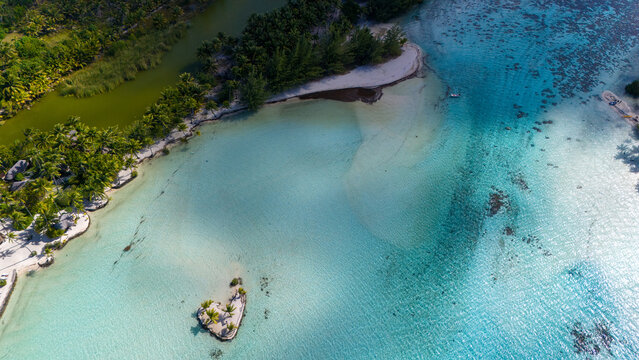 Beautiful azure ocean water seen from an aerial drone view over tropical island Taha'a in French Polynesia. 
