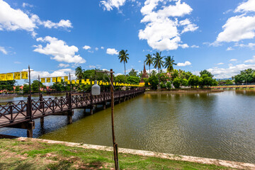 Background of Wat Traphang Thong, which is located in the middle of the water and has a wooden bridge, which is used to organize ceremonies (Loi Krathong, New Year) in Sukhothai province, Thailand.