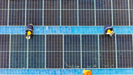 Worker Technicians are working to construct solar panels system on roof. Installing solar photovoltaic panel system. Men technicians walking on roof structure to check photovoltaic solar modules.