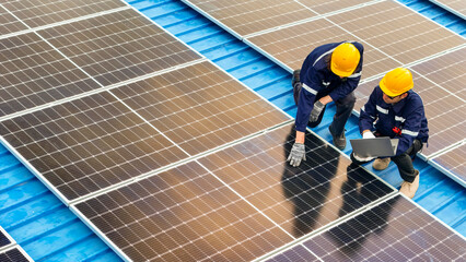 Photovoltaic engineers work on roof top warehouse. workers Inspect and repair the solar panel...