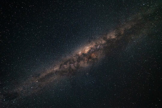 The Milky Way galaxy stretching across a dark starry sky as seen from Australia. You can see billions of shining stars and the cloudy nebula, only a small part of our amazing and wondrous universe. - Powered by Adobe