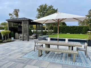 High-end outdoor living space, a backyard patio with pergola, outdoor rug,  tequila bar, dining...
