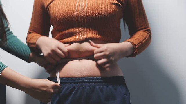fat woman, fat belly, chubby, obese woman hand holding excessive belly fat with measure tape, woman diet lifestyle concept