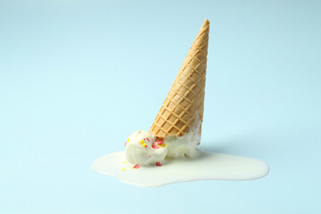 Melted ice cream in wafer cone on light background