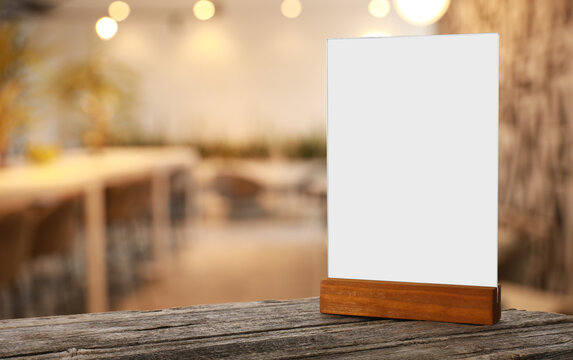 Menu holder with blank card on wooden table in cafe. Mockup for design