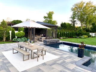 High-end outdoor living space, a backyard patio with pergola, outdoor rug,  tequila bar, dining...