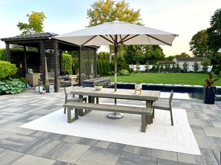 High-end outdoor living space, a backyard patio with pergola, outdoor rug,  tequila bar, dining...