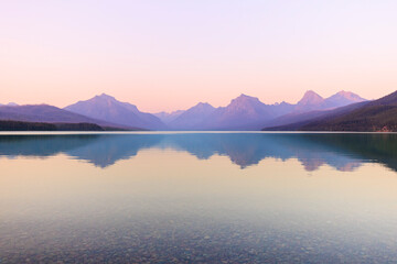 Mountains reflect in Lake McDonals in Glacier National Park at sunset