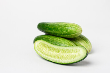 Whole and cut long cucumbers isolated on white