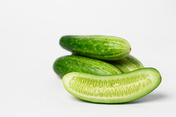 Whole and cut long cucumbers isolated on white