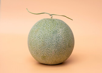 Green pearl Melon fruit fully ripe juicy and sweet on the orange scene background.