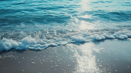 Fototapeta premium Azure Serenity: Gentle waves crest and foam on a sun-kissed beach, inviting tranquility and escape.