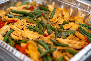 Stir fry chicken, sweet peppers and green beans. Served in a silver catering container delivered for an event
