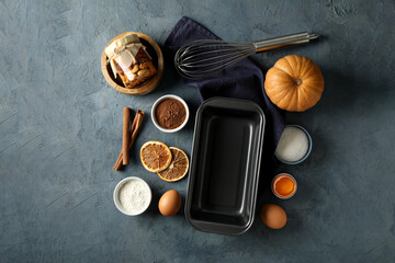 Ingredients and tools for baking, nuts, pumpkin and cinnamon sticks on gray background, top view