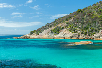 Fototapeta premium Turquoise waters and rocky shoreline at Two Peoples Bay in Western Australia, near Albany. Perfect for projects featuring coastal scenery, travel destinations, or natural beauty themes.