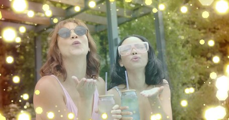 Holding drinks and blowing kisses, women with sunglasses over glowing hexagons animation