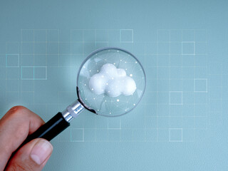 Cloud computing infrastructure technology, data system storage connection concept. Polygon graphic on white cloud in magnifying glass lens in businessman hand on light blue background, minimal style.