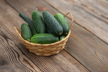 Cucumbers in a wooden bowl on a wooden background
