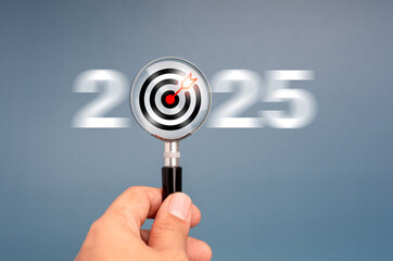 Happy new year 2025 with business trends concept banner. Target icon inside magnifying glass holding by hand with motion blur of white 2025 number on grey background. finding goal.and success concept.