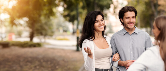 Friendship With Ex. Girl Talking With Married Couple Of Friends Walking In Park Outside. Selective Focus