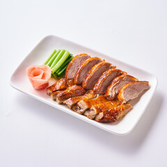 Roast pork and crispy pork with Chinese sausage on a white plate with side vegetables and pickled ginger.