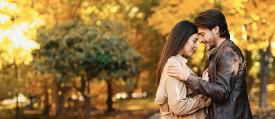 Couple in love embracing and touching each other with foreheads in autumn park