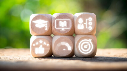 Wooden blocks with icons representing education, training, skill development, and success in an...