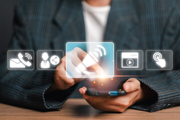 Hand interacting with digital icons on a smartphone, representing modern business and marketing...