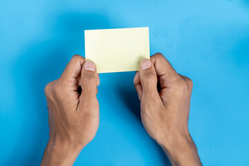 A person holding a yellow card with a blank space