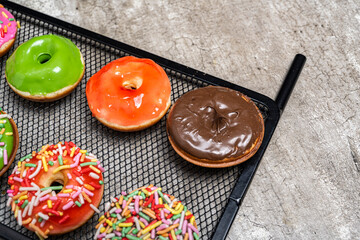 A tray of assorted mini donuts with a chocolate one in the middle