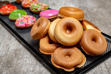 A tray of assorted mini donuts with sprinkles and frosting