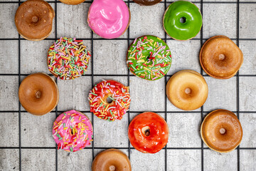 A tray of assorted mini donuts with sprinkles and frosting