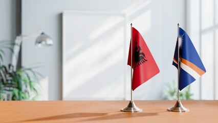 FLAGS OF ALBANIA AND MARSHALL ISLANDS ON TABLE