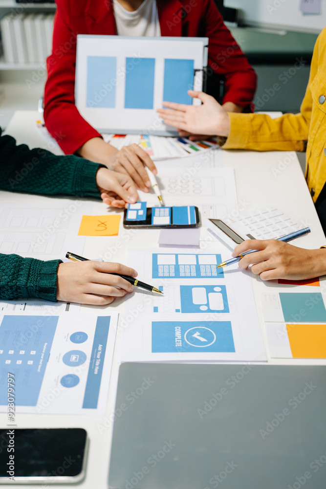 Wall mural close up view of ui developer team brainstorming on their project with laptop, smartphone and digita