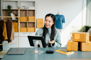 Young business owner woman prepare parcel box and standing check online orders for deliver