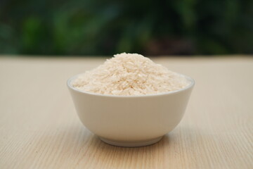 rice in a bowl with wooden background