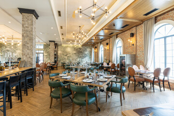 Interior of an empty large hotel restaurant with brick walls