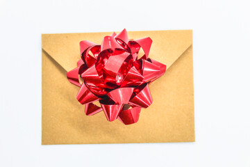 selective focus isolated on white, brown vintage envelope with red ribbon ornament in the shape of a flower symbolizes love for a gift for a loved one, writing template
