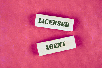 Text LICENSED AGENT written the inscription is composed on a colored background of wooden blocks