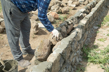 Fototapeta premium Craftsman working in rough stones in outdoor.