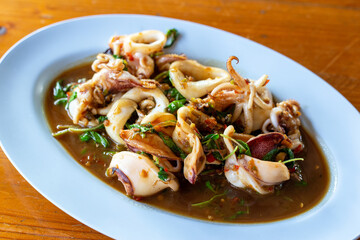 Stir-fried spicy thai basil with fresh squid (Pad Kra Prao Pla Muek). Seafood recipes popular in local street food.