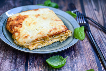  Italian Lasagna bolognese  covered with parmesan cheese  on awooden  background.