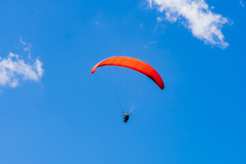 View of the sky. Person flying in a paraglider, leisure activity. Travel and landscapes.